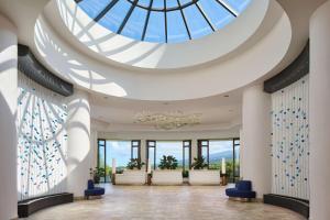 科纳Outrigger Kona Resort and Spa的大堂设有玻璃天花板和蓝色椅子