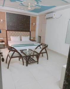 新德里Hotel MARISA GRAND Near Delhi Airport BY Aero Home的配有床、桌子和沙发的房间