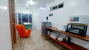 巴科洛德Liturs Travel Services / Homestay / Rent a Car的客厅配有橙色椅子和微波炉
