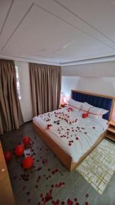 纳祖尔Hotel Residence Ramsis的卧室铺有红色玫瑰花瓣。
