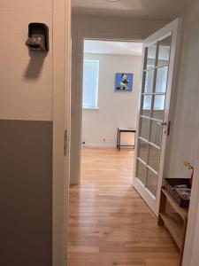 比伦德5 minute walk to LEGO house-70m2 apartment with garden-unit C的走廊上设有一扇门,通往铺有木地板的客房