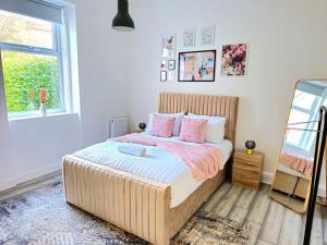 格拉斯哥Spacious Haven with Free Parking的卧室配有一张带粉红色枕头的大床