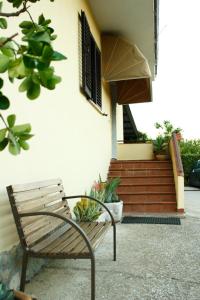 阿韦利诺GuesthouseAntonia的坐在房子前面的木凳