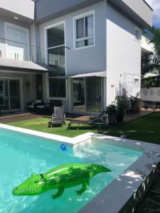 弗洛里亚诺波利斯Casa Luxo com piscina a 500 metros da praia的 ⁇ 在房子前的游泳池中的海龟