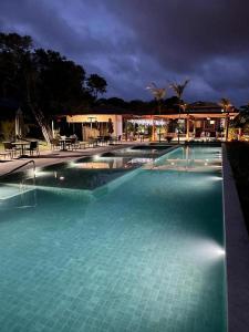 马塔迪圣若昂Praia do Forte - COND ALTO DA ENSEADA - Casa 302的夜间蓝色海水的大型游泳池
