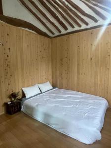 庆州Stay Moon Charm的卧室设有白色的床和木墙