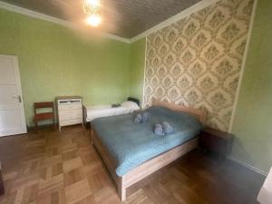 阿巴斯图马尼Abastumani Apartment的一间设有床铺的卧室,位于一个拥有绿色墙壁的房间