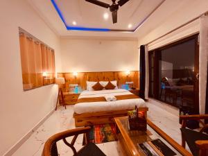 朱纳格特Siluswar Hotel的一间卧室配有一张床、一张桌子和一个窗户。