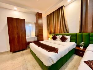 贾姆讷格尔Sanju Valley View的一间卧室配有一张大床和一张绿色沙发