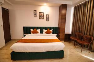 贾姆讷格尔Sandhu Lodge的酒店客房带一张大床和椅子