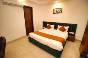 贾姆讷格尔Sandhu Lodge的一间卧室配有一张带橙色枕头的大床