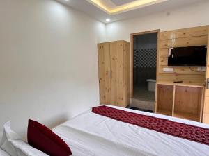 贾姆讷格尔Sharma Farms的一间卧室配有一张床,并在一间客房内配有电视。