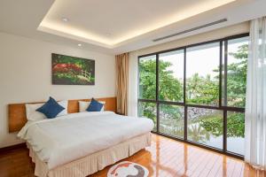 岘港Ocean Sunny Villas Da Nang的一间卧室设有一张床和一个大窗户