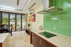 岘港Ocean Sunny Villas Da Nang的厨房配有绿色台面和桌子