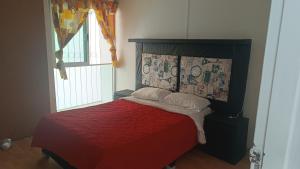 墨西哥城Las flores Boulevard的一间卧室配有一张带红色毯子的床和窗户。