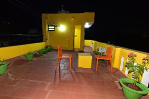 蓬蒂切里Chez Linda Home Stay的庭院设有橙色椅子和黄色墙壁