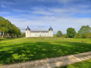 瓦朗赛VILLA ESPERANZA Chambre 2 proche Zoo de Beauval et Châteaux de La Loire的一座白色的大建筑,在田野顶部有两个圆顶