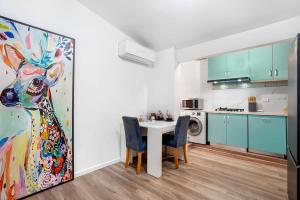 墨尔本Prime Modern Brilliance with Prahran Convenience的厨房配有桌子和一幅妇女画