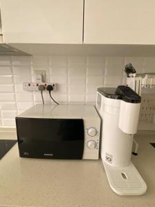 吉隆坡Luxury Continew Residence with KLCC,TRX,Ikea View的厨房柜台配有微波炉和咖啡壶