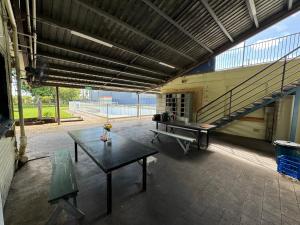 艾尔Ayr Budget Accommodation的配有乒乓球桌和长凳的房间