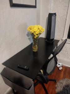 帕特森Clearviewpeace的一张桌子上的黄色花瓶,配有电视