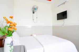 Nhơn TrạchHotel Trâm Anh 2的一间设有床铺和花瓶的房间