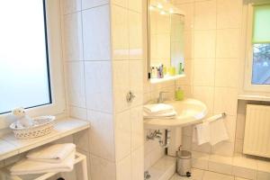 韦斯特兰Krabbenliebe的白色的浴室设有水槽和淋浴。