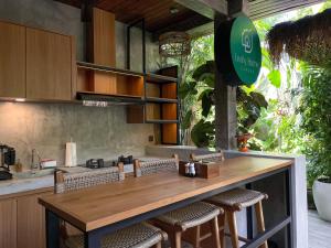 坎古Leafy Home Canggu的厨房配有带椅子的柜台和台面