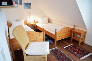 文尼斯塔特3-Zimmer Appartement in Wenningstedt in ruhiger Lage的小房间设有两张床和椅子