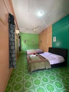瓜拉勿述B'first Chalet Perhentian Island的绿墙客房内的两张床
