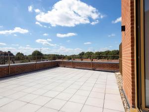 米查姆Modern Apartments with Balcony in Merton near Wimbledon by Sojo Stay的一个带砖墙和蓝色天空的庭院