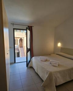 巴里萨尔多斯特拉迪雷斯特住宅酒店的一间卧室配有一张床,上面有两条毛巾