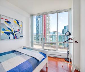 温哥华Designer sub-penthouse - Central Downtown Views And King Bed!的一间卧室设有一张床和一个大窗户