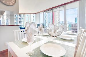 温哥华Designer sub-penthouse - Central Downtown Views And King Bed!的餐桌,上面有白板和玻璃杯