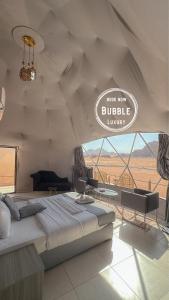 瓦迪拉姆Wadi rum Bubble luxury camp的一间卧室,配有一张床和一个阅读豪华书籍的标志