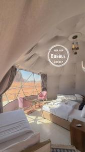 瓦迪拉姆Wadi rum Bubble luxury camp的一间卧室设有两张床和一个阅读了埋藏豪华的标志