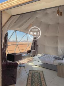 瓦迪拉姆Wadi rum Bubble luxury camp的帐篷,配有床和阅读气泡疗法的标志