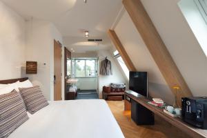 内斯凡赫克伦酒店的卧室配有白色的床和电视