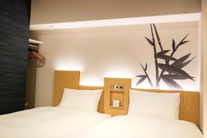名古屋Daiwa Roynet Hotel Nagoya Fushimi的卧室内的两张床,配有白色床单