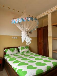 班基Gust Hotel的一间卧室配有一张带绿色和白色棉被的床