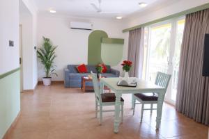 巴加Richmonde Ananta Elite Luxurious Villa & Apartments,Goa的客厅配有桌椅和沙发