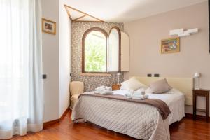 米萨诺阿德里亚蒂科Villa Le Rose - 5 minuti dal mare e Misano World Circuit的一间卧室设有一张床和一个窗口