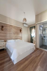 博兹贾阿达岛Karina Vineyard House的卧室配有一张白色大床和木制床头板
