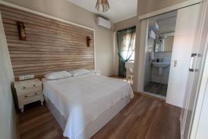 博兹贾阿达岛Karina Vineyard House的一间带白色床的卧室和一间浴室