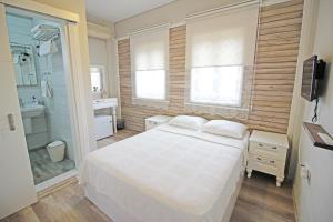 博兹贾阿达岛Karina Vineyard House的卧室配有白色的床和淋浴