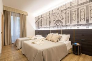 佛罗伦萨Hotel Mia Cara & Spa的酒店客房,配有两张带白色床单的床