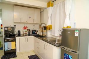 内罗毕Powerground Resort的小厨房配有白色橱柜和冰箱。