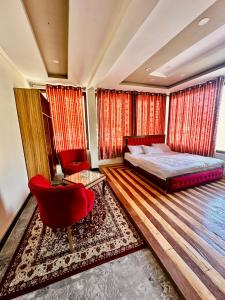 锡卡都Skardu Luxus Hotel的一间卧室配有一张床和一张红色椅子