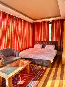 锡卡都Skardu Luxus Hotel的一间卧室配有一张床、一张沙发和一张桌子