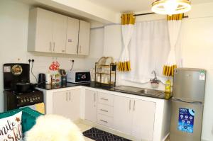 内罗毕Powerground Resort的厨房配有白色橱柜和冰箱。
